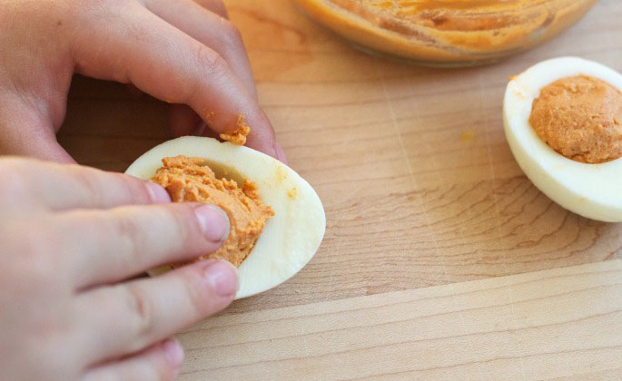 Riempire con l'impasto di zucca e tuorlo le uova sode tagliate a metà