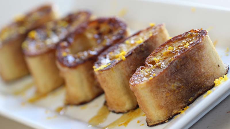 Pain perdu dolce con tronchetti di baguette, sciroppo d'acero e scorzette d'arancia non trattata