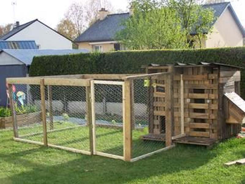 Pollaio e recinzione realizzati con pallets di recupero integrati architettonicamente nel contesto del giardino