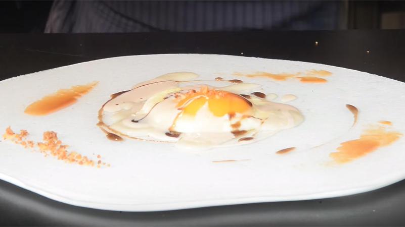 Il burro nocciola aromatizzato e la salsa di tartufo nero a coprire l'uovo