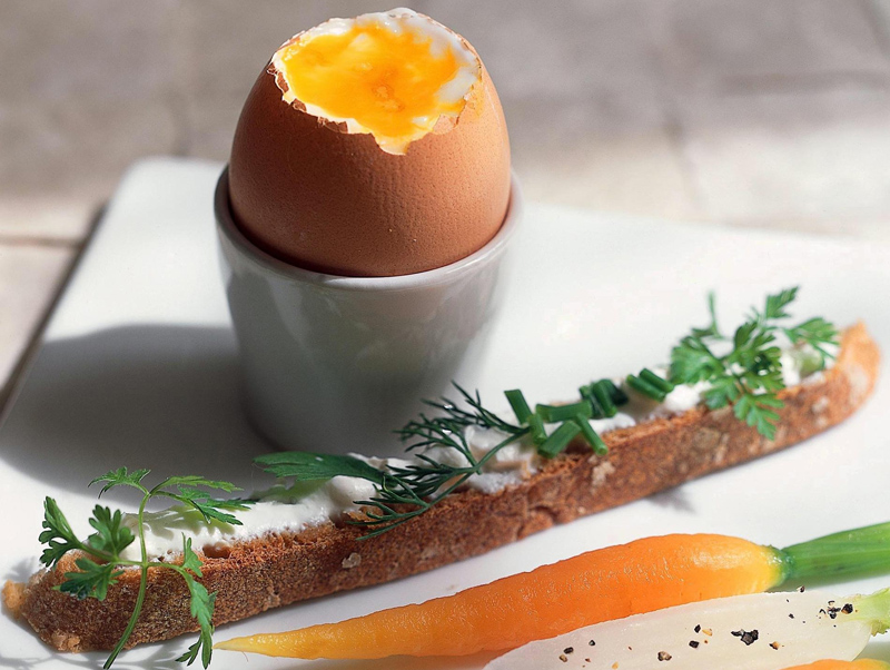 Uovo alla coque con verdure al vapore (ad esempio carote) ed erbette aromatiche