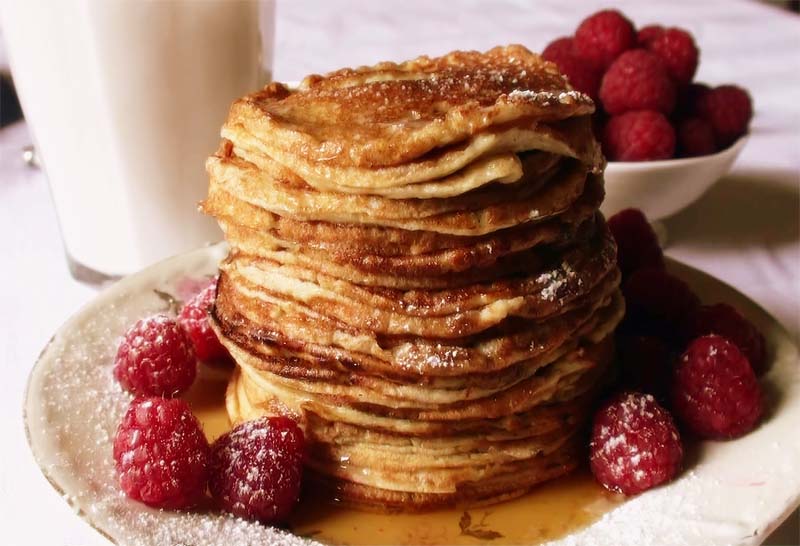 Torre di pancake con sciroppo d'acero e lamponi