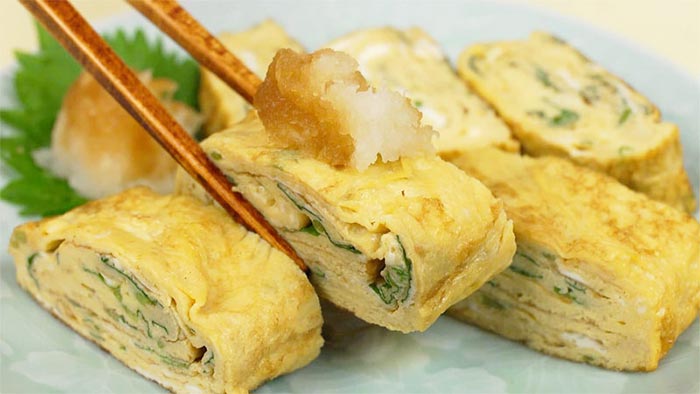 L'inserimento di ingredienti aggiuntivi nella frittata Tamagoyaki (ad esempio erbette, cipollina e alga nori).