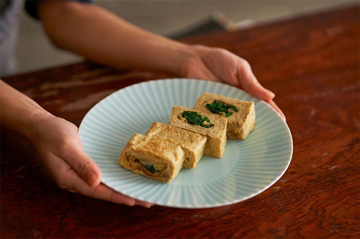 L'inserimento di un ripieno centrale in una frittata Tamagoyaki