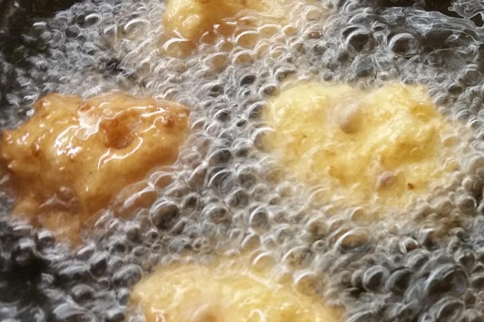 La frittura delle frittelle di riso in olio di arachidi bollente