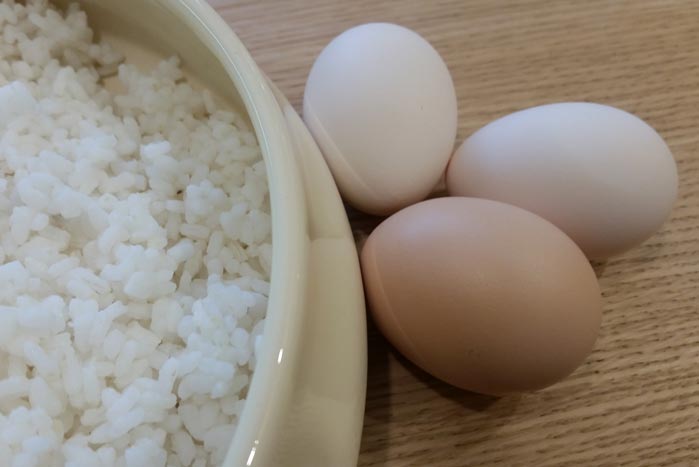 Il riso lessato e raffreddato e le uova fresche delle galline