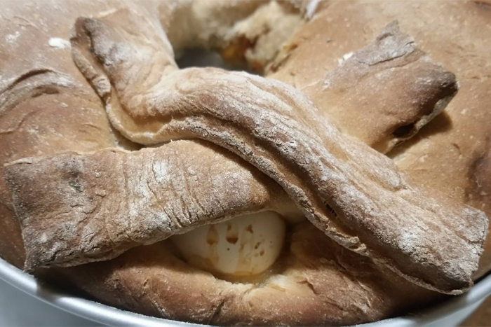 L'uovo incastonato nella ciambella con una croce fatta di impasto - Ricetta Casatiello Napoletano