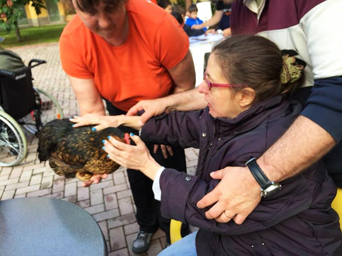 Anziana accarezza la gallina Nerina